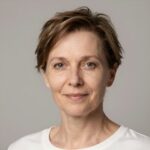 Портрет уверенного российского бизнесмена с дружелюбным взглядом на размытом нейтральном фоне в студии